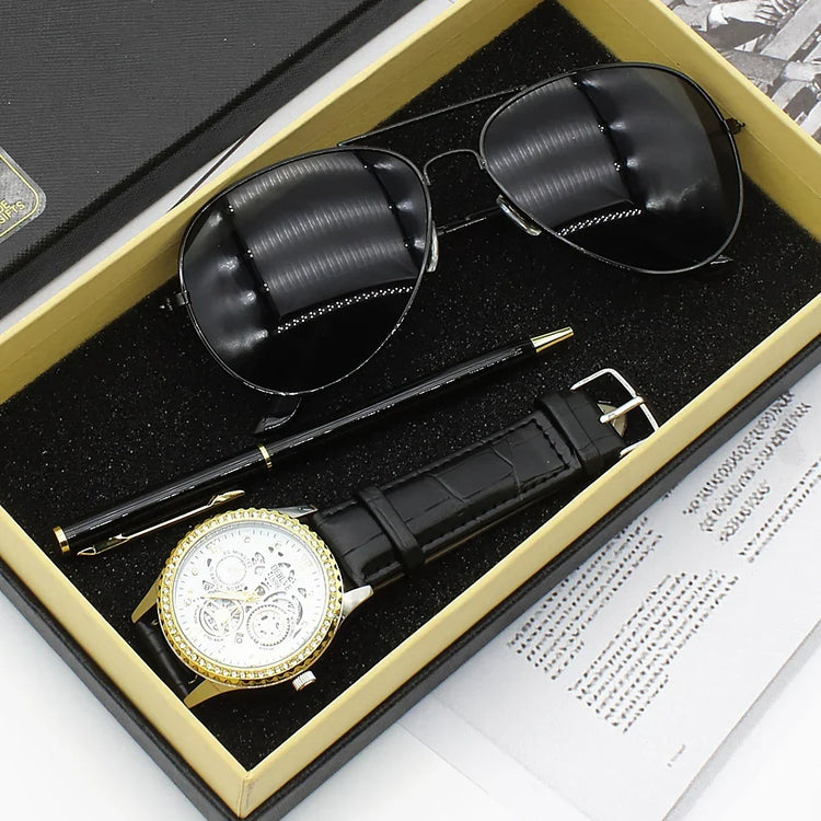 Gift box with black aviator sunglasses, gold and black wristwatch, black leather strap, and black pen