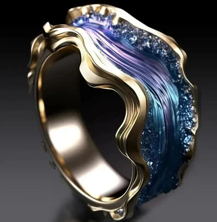 Gold ring with sculpted wave-like edges and shimmering blue crystal detail, modern style