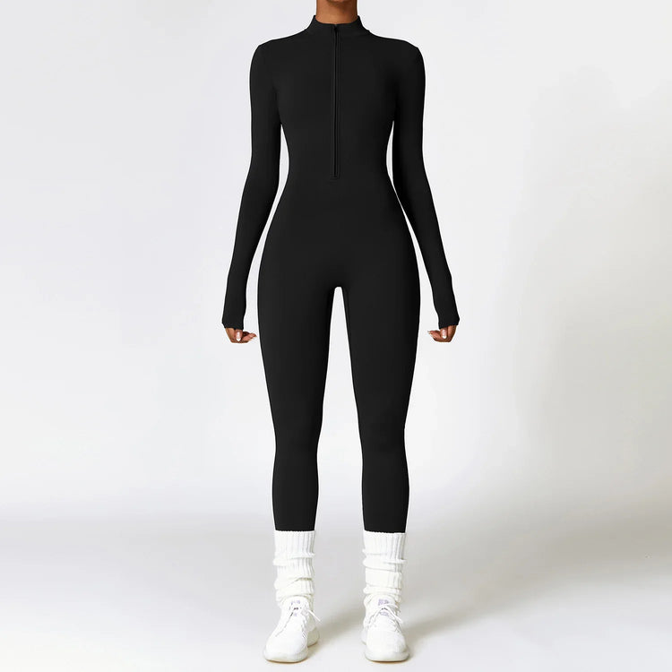 Woman wearing a black fitted long sleeve jumpsuit with front zipper, white socks, and sneakers