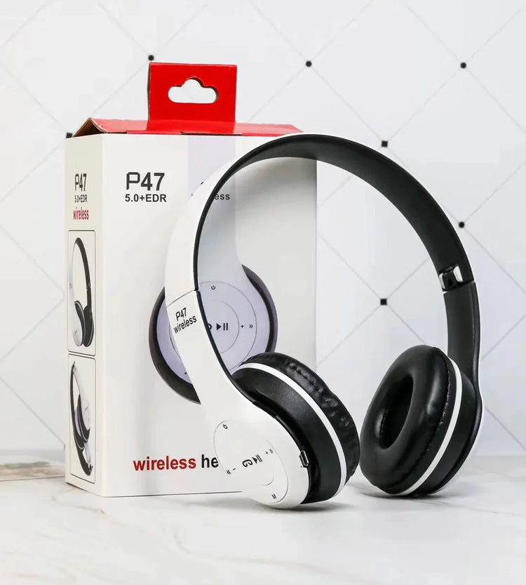 White and black over-ear wireless headphones with cushioned ear pads, shown beside retail box.