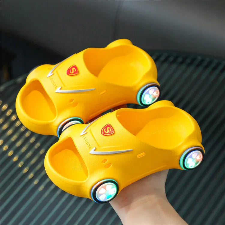Yellow car-shaped slippers with open toe, soft foam material, and light-up wheels