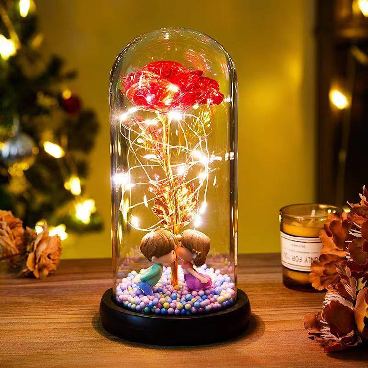 Romantic LED glass dome lamp with red rose, fairy lights, and two figurines on a wooden table