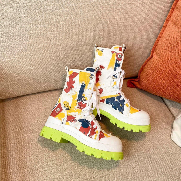 Chunky lace-up canvas boots with colorful paint splatter and neon green soles, streetwear style.