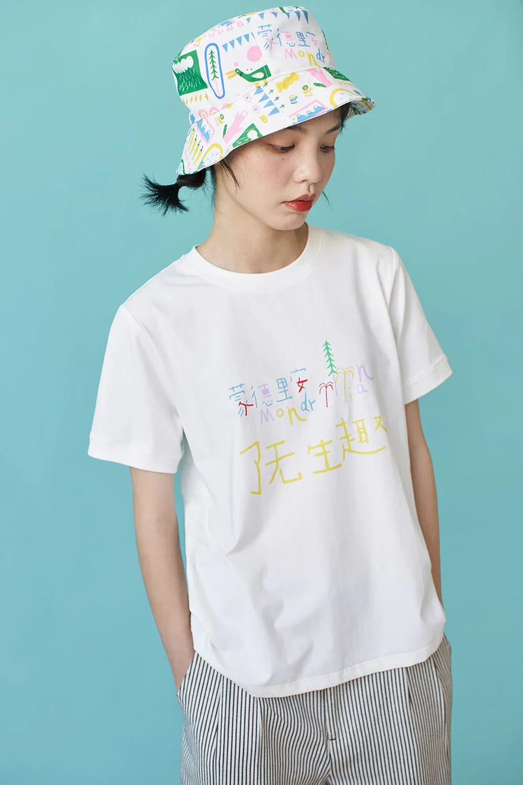 Woman in relaxed fit white graphic t-shirt, striped shorts, and colorful bucket hat