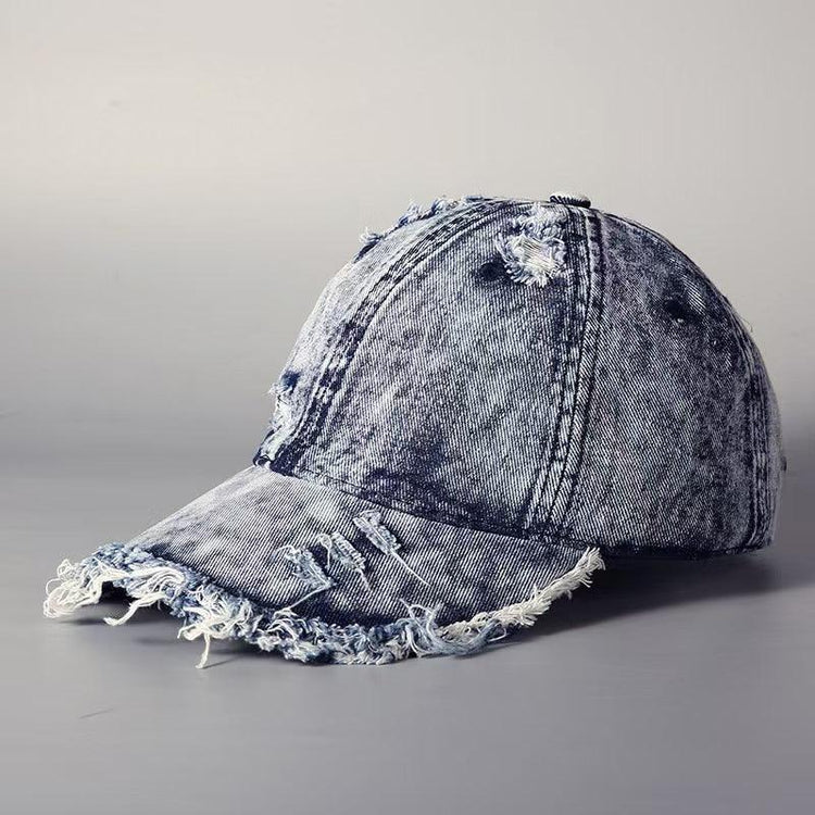 Distressed denim baseball cap with frayed edges and washed blue finish, streetwear style