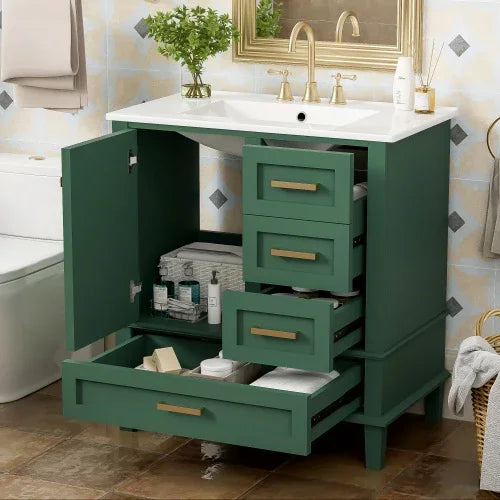 Modern green bathroom vanity with gold handles, white countertop, open drawers and cabinets showing towels and toiletries, contemporary interior setting.