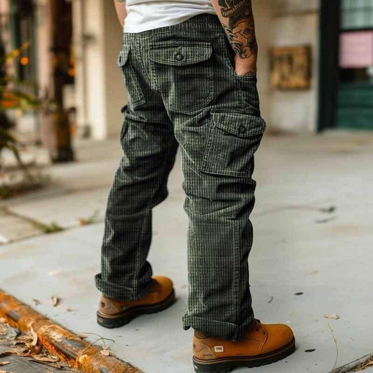 Man wearing green corduroy cargo pants with relaxed fit and tan work boots outdoors