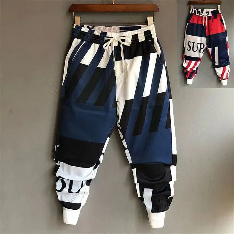 Colorblock streetwear jogger pants with bold navy, black, and white geometric patterns, relaxed fit