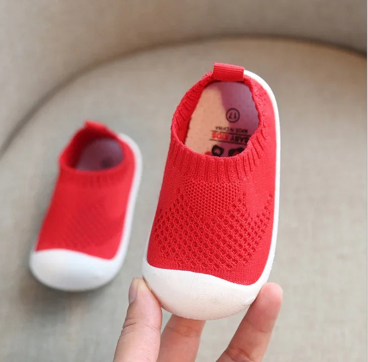 Red knit slip-on baby shoes with white rubber soles and breathable mesh design
