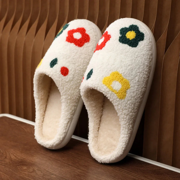 White fuzzy slippers with colorful flower patterns, slip-on design, cozy indoor footwear.