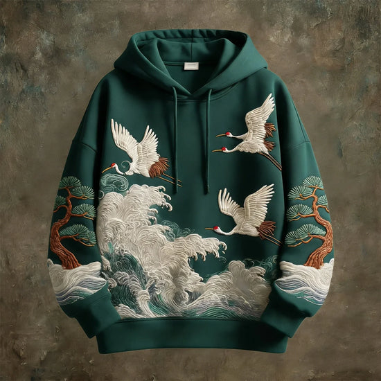 Green oversized hoodie with embroidered cranes, pine trees, and waves, streetwear style.