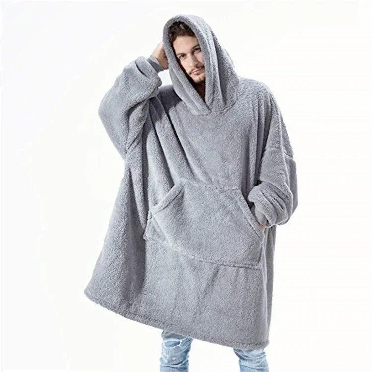 Man wearing oversized grey fleece hoodie with large front pocket and relaxed fit.