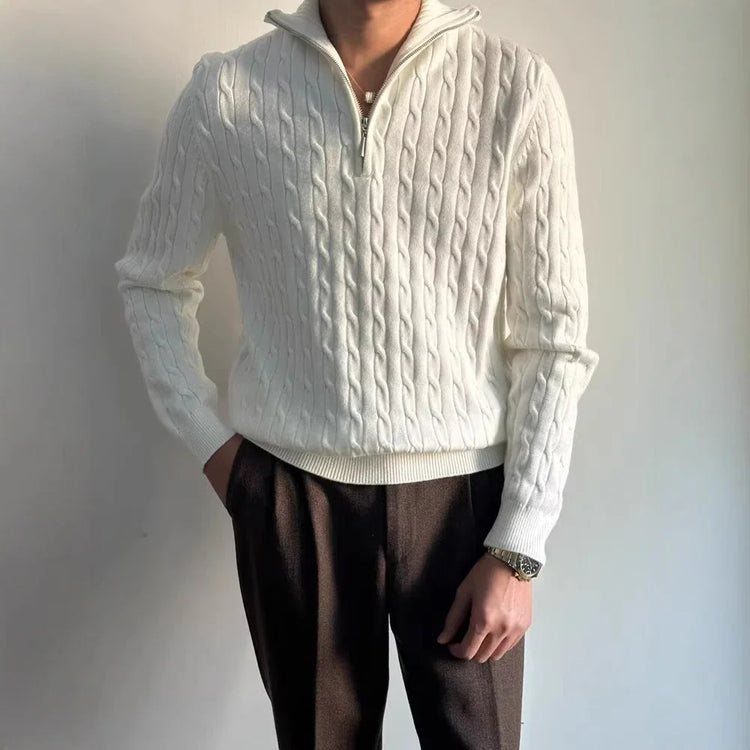 Man wearing a white cable knit quarter-zip sweater with relaxed fit, paired with dark trousers