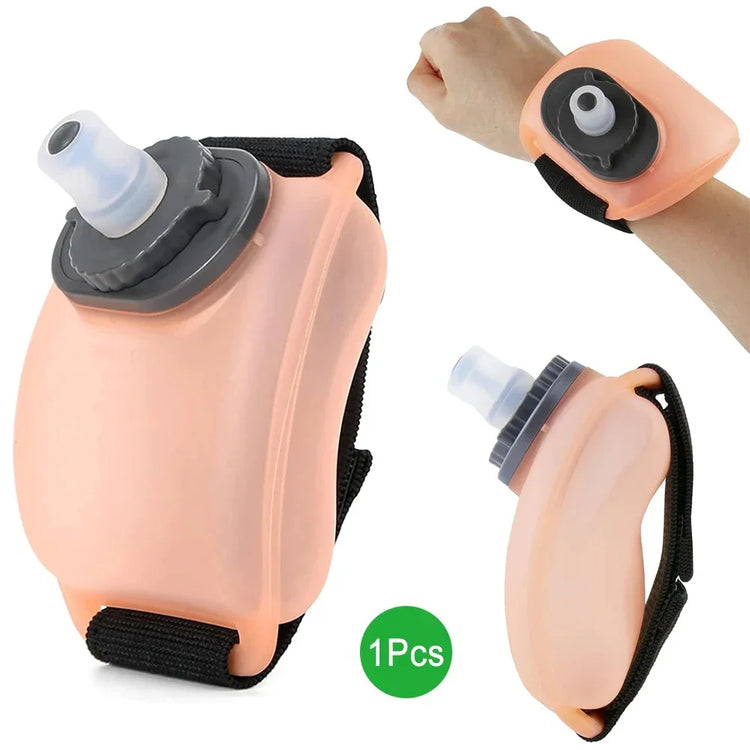 Peach-colored silicone wrist water bottle with black adjustable strap and gray cap.