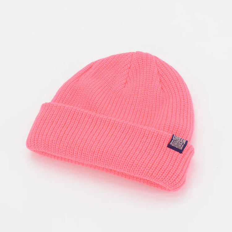 Bright pink ribbed knit beanie with folded brim, soft acrylic material, relaxed fit