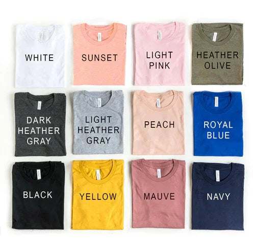 Assorted Be Kind T-shirts in various colors neatly folded displaying color names