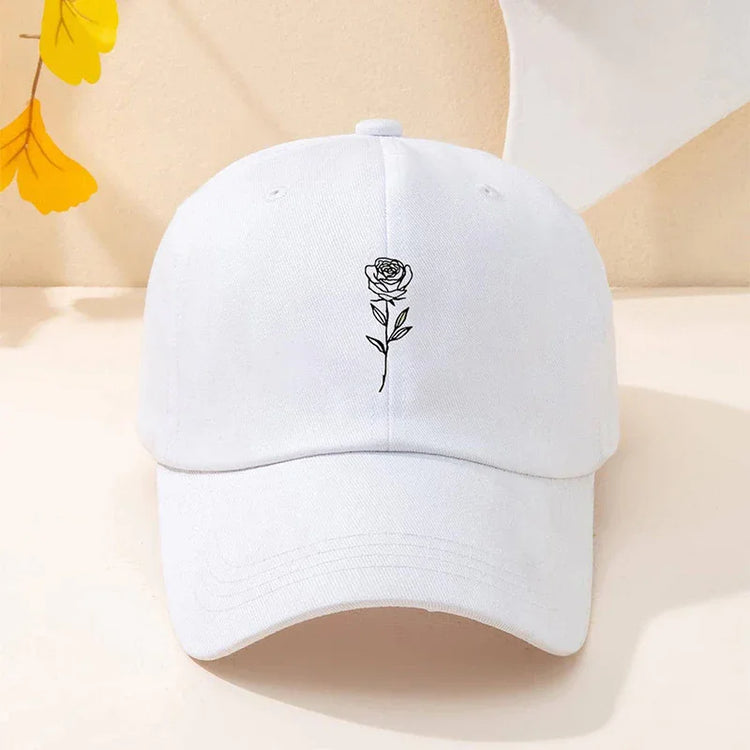 White cotton baseball cap with minimalist black rose embroidery, curved brim, relaxed fit