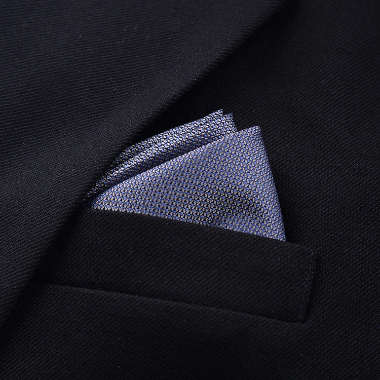 Close-up of a textured blue pocket square in a black suit jacket pocket, slim fit style