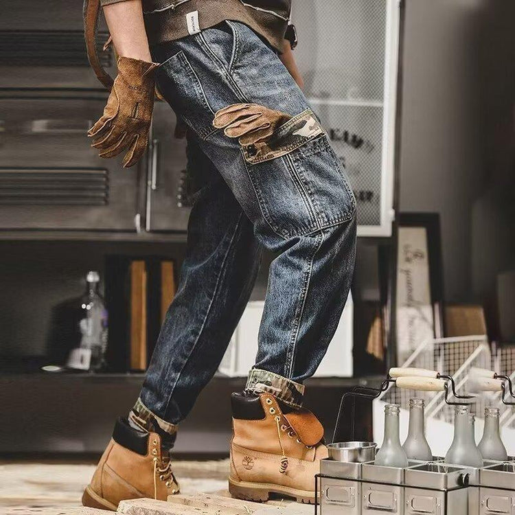 Baggy blue denim cargo jeans with camo pocket, brown work gloves, tan suede boots, relaxed fit