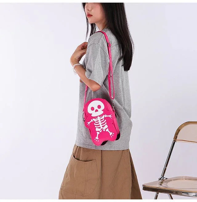 Woman wearing oversized gray t-shirt, khaki wide-leg pants, and carrying pink skeleton crossbody bag