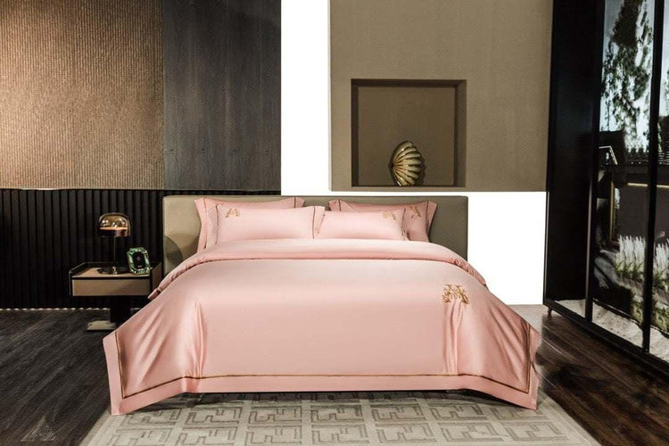 Modern bedroom with blush pink satin bedding, gold embroidery, and minimalist decor.
