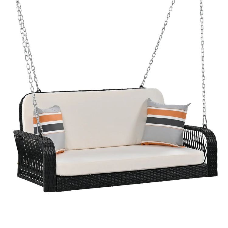 Black wicker hanging swing with cream cushions and striped accent pillows