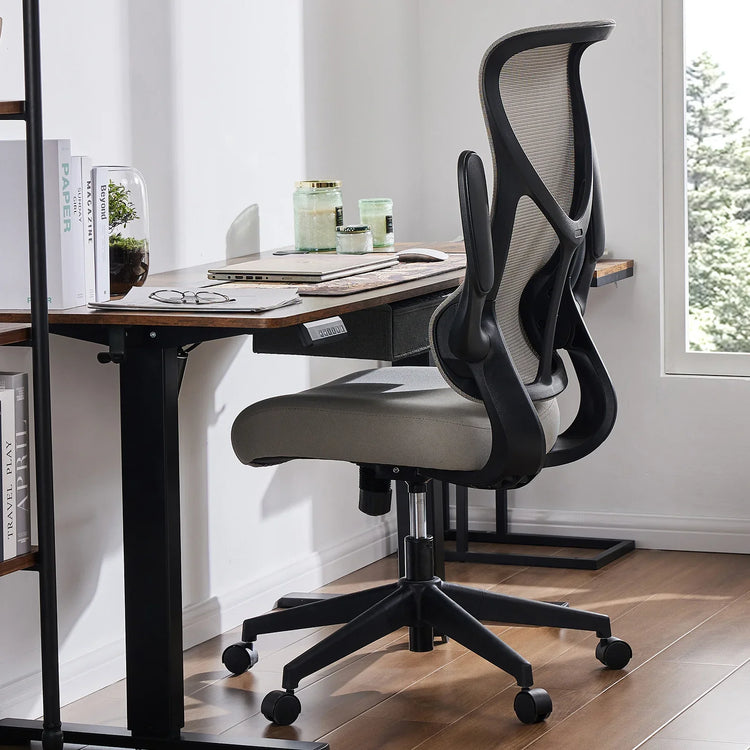 Modern ergonomic mesh office chair with gray cushioned seat and black frame at a minimalist desk