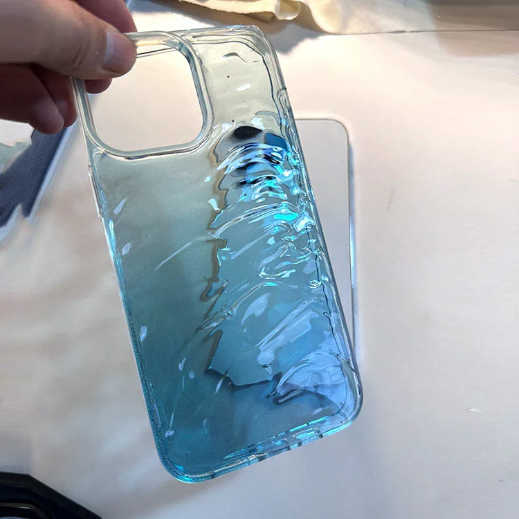 Clear blue gradient phone case with glossy, textured wave design, held in hand