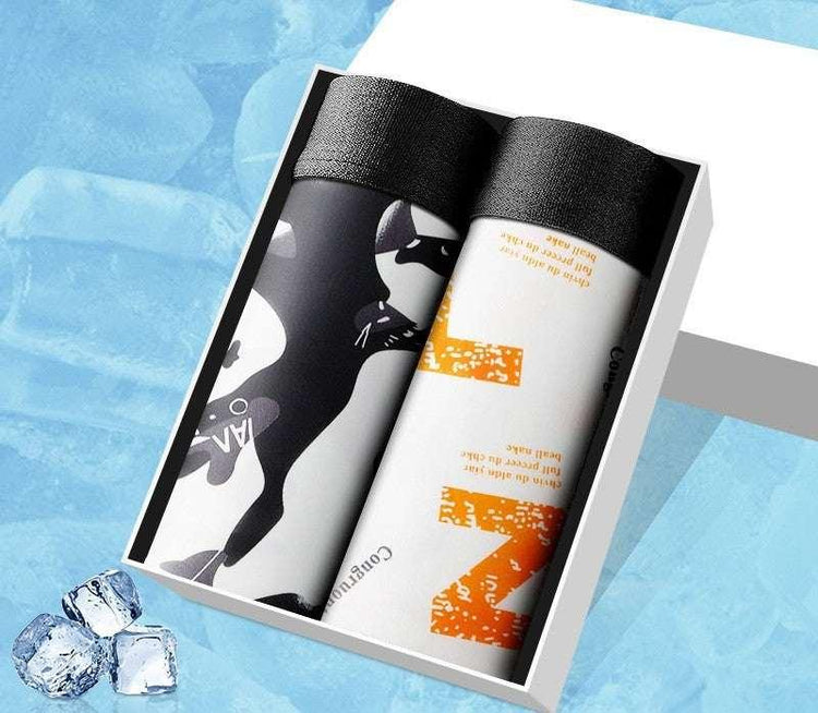Boxed set of two rolled streetwear socks, one with black and white camo pattern, one with orange print, cotton material, modern style.