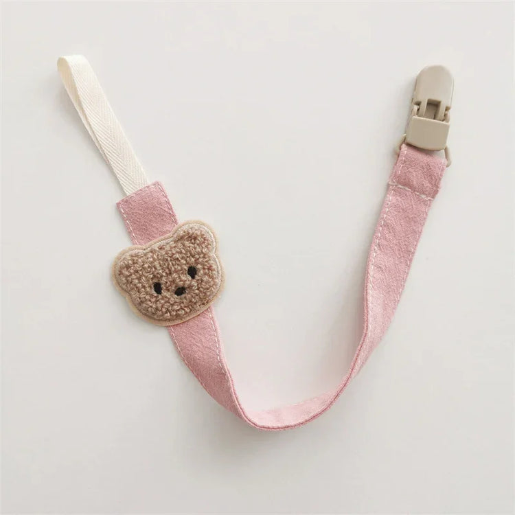 Pink fabric pacifier clip with beige crochet bear head and plastic clasp, cute accessory