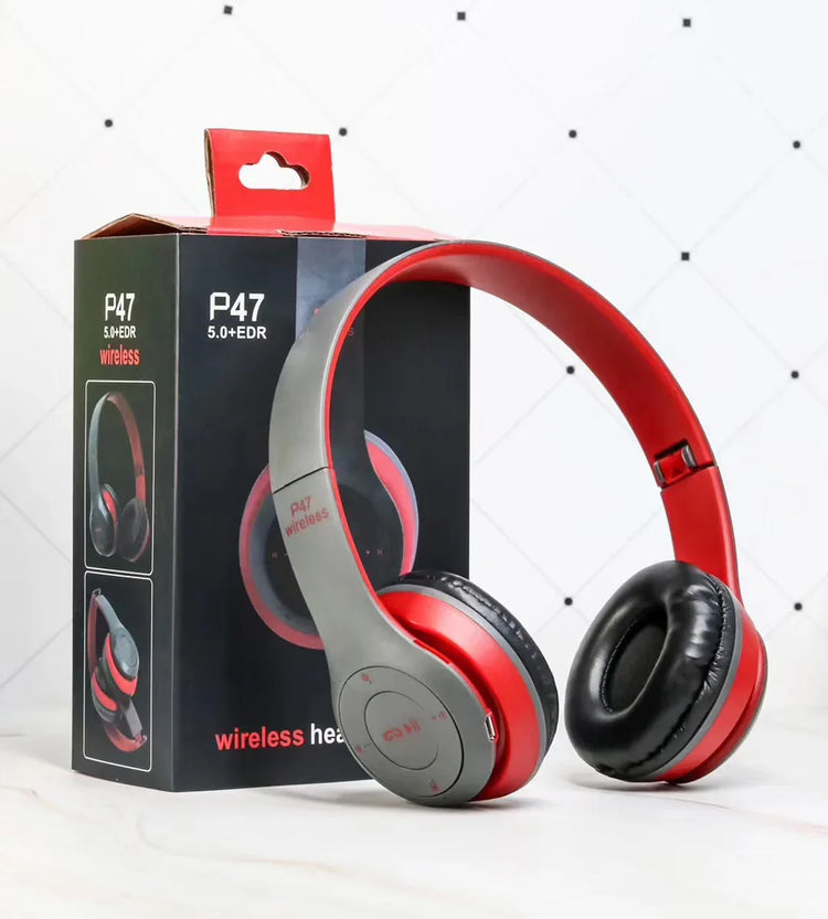 Gray and red wireless over-ear headphones with cushioned ear pads, tech accessory box visible
