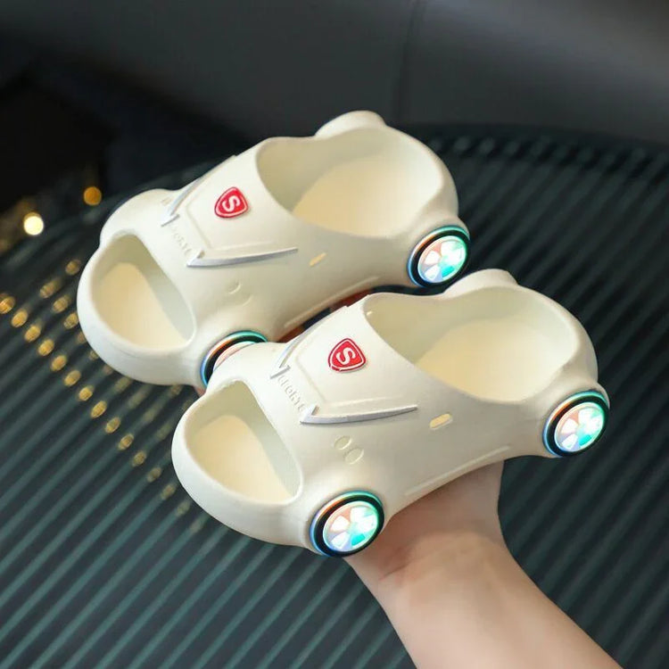 Beige slip-on foam sandals shaped like cars with colorful wheel accents and open toes.