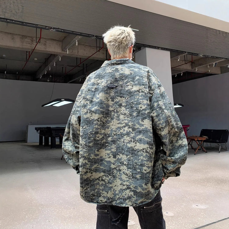 Oversized digital camo jacket in green tones, relaxed fit, worn in modern indoor space
