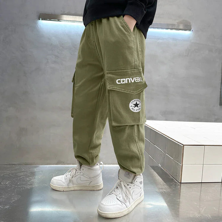 Olive green cargo pants with large side pockets and relaxed fit, styled with white sneakers