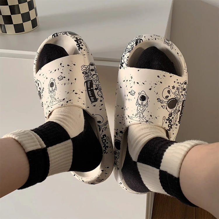 Beige slides with black cartoon space print, paired with black and white checkered socks