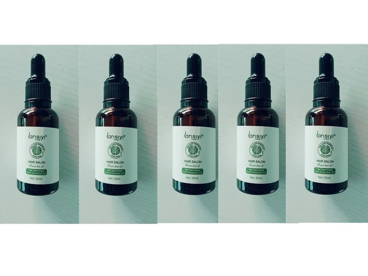 Five brown dropper bottles with white labels, containing essential hair oil, displayed in a row.