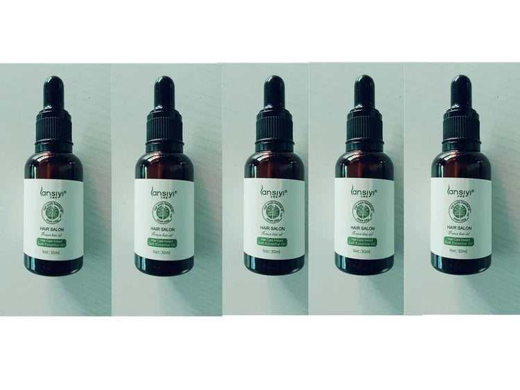 Five brown dropper bottles with white labels, containing essential hair oil, displayed in a row.