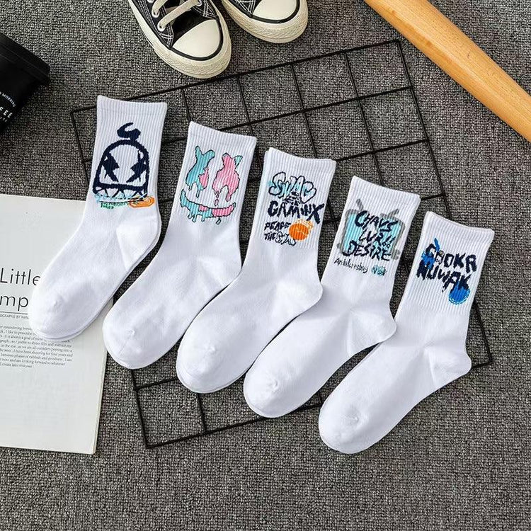 Five pairs of white cotton crew socks with colorful graffiti streetwear designs, laid on a gray surface.