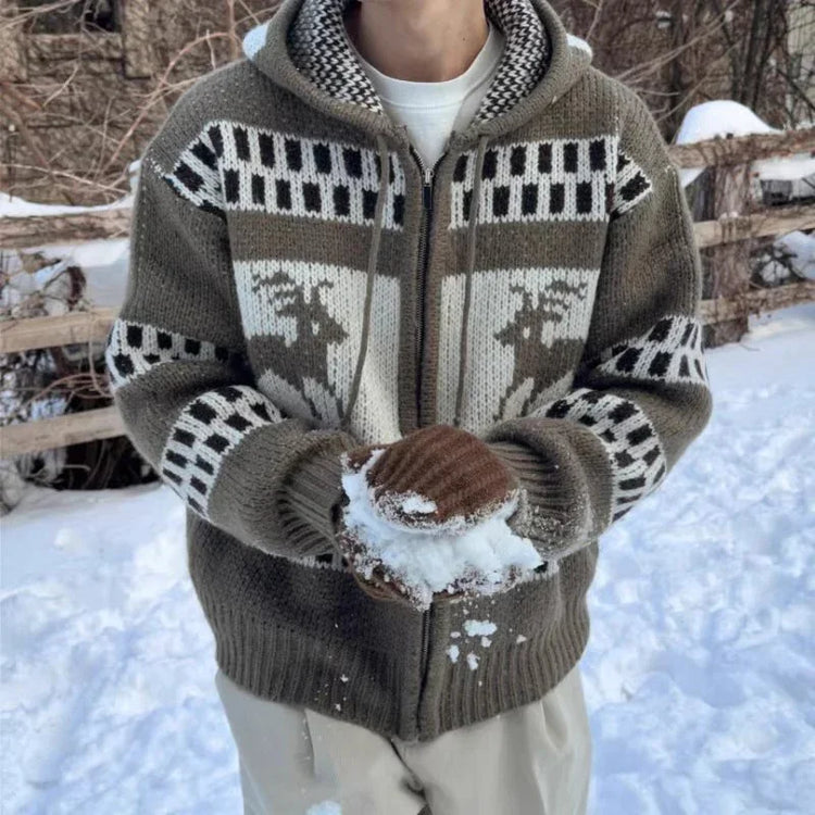 Person wearing a brown knit cardigan hoodie with reindeer pattern and mittens, relaxed fit in snow
