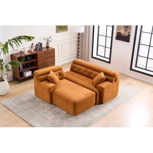 Modern orange fabric sofa set with tufted backrest and matching cushions on a gray rug in a bright living room.