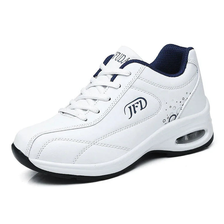 White athletic sneaker with air-cushioned sole, lace-up design, and navy mesh lining.