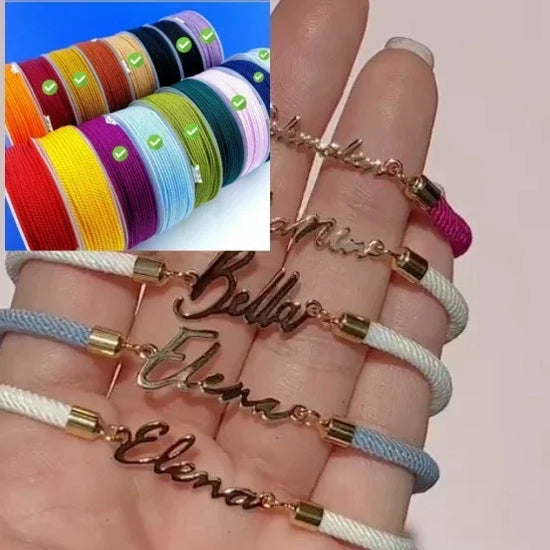 Hand holding personalized rope bracelets with gold nameplates, shown in various pastel and bright colors.