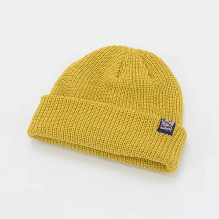 Mustard yellow ribbed knit beanie with folded cuff and relaxed fit.