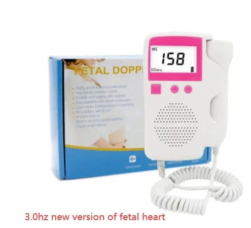 White and pink handheld fetal doppler with digital display, coiled probe cord, packaging box in background