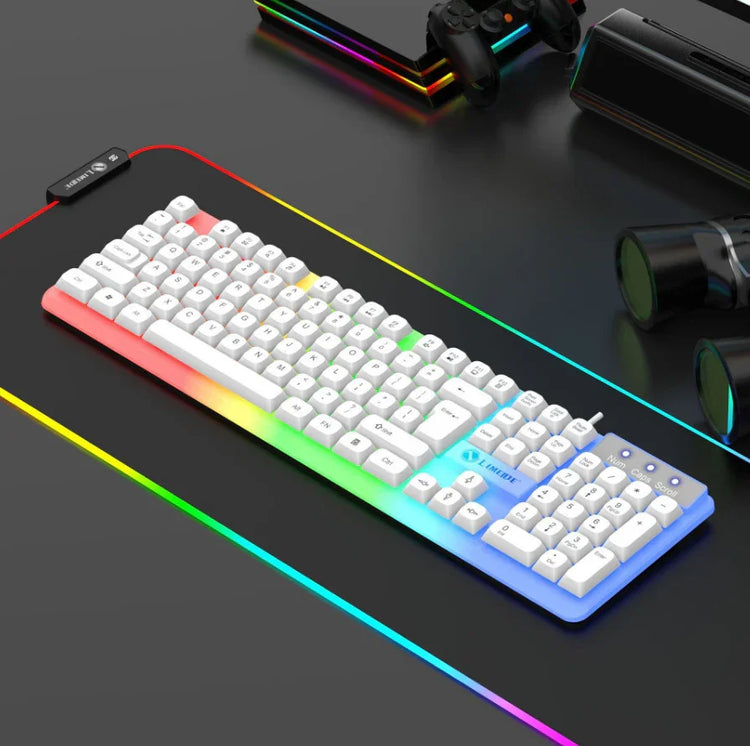 White mechanical keyboard with RGB backlighting on a black RGB gaming desk mat, tech accessories nearby.
