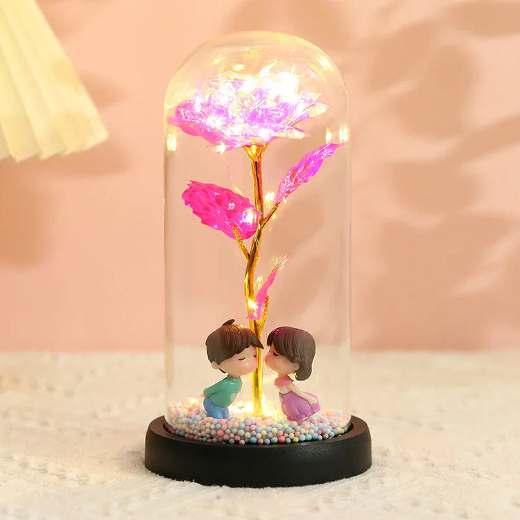 Glass dome light with glowing pink flower and figurines, decorative home accessory