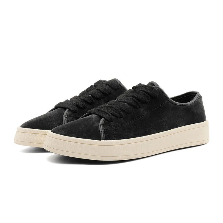 Black suede low-top sneakers with chunky cream rubber soles and lace-up design