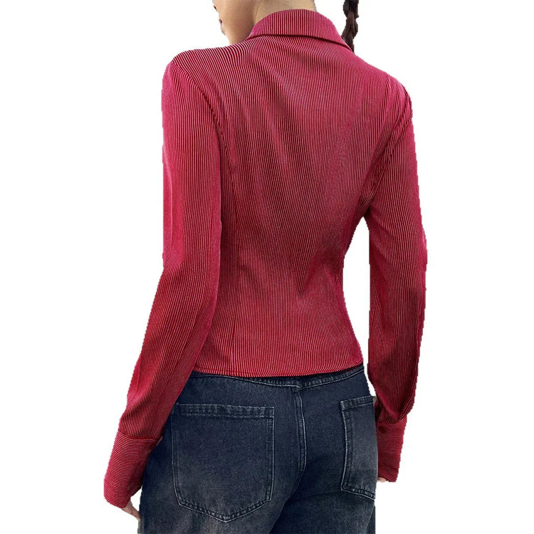 Woman wearing a fitted red ribbed long sleeve top and high-waisted dark denim jeans