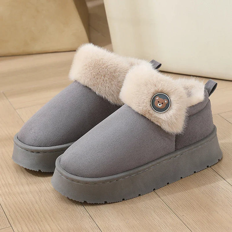 Gray suede slip-on winter shoes with plush beige fur trim and round teddy bear button detail