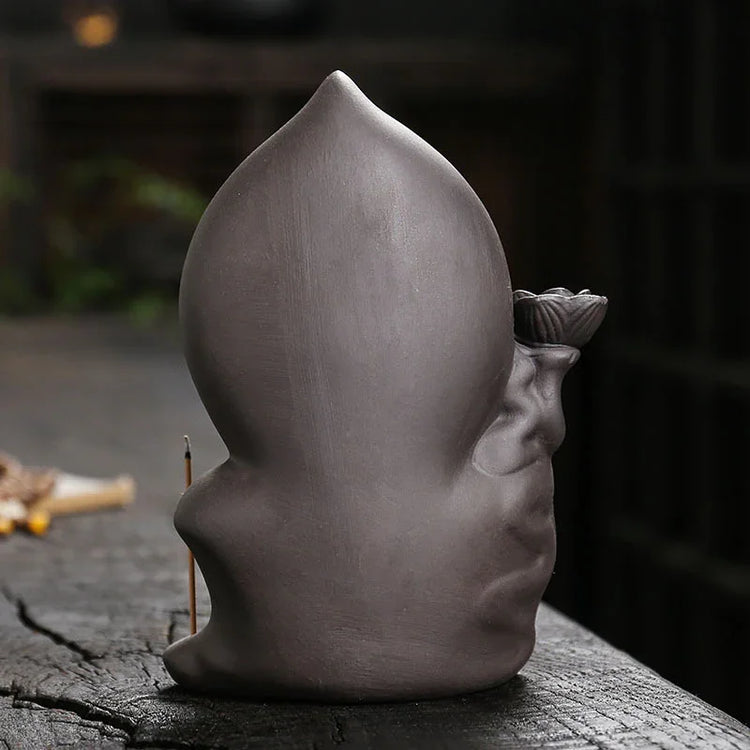 Matte grey ceramic sculpture with a rounded teardrop shape, smooth finish, and organic lines